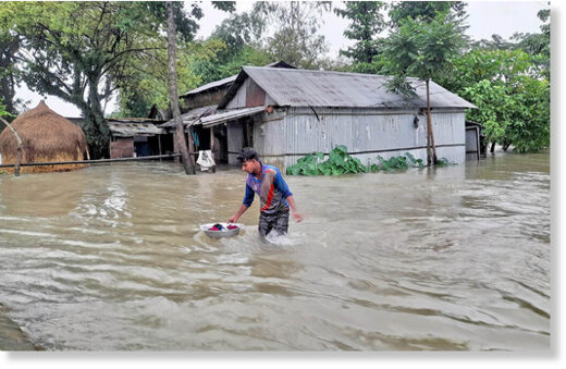 A man trudges through flood water in Gowainghat upazila of Sylhet on Thursday, June 16, 2022