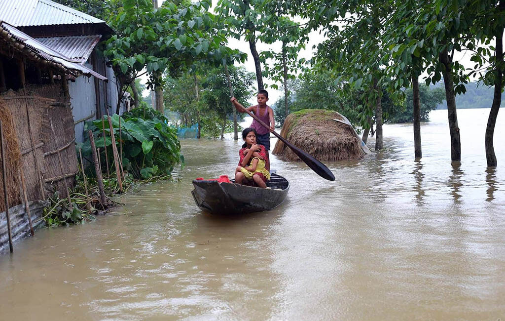 Children use a boat for transportation in a flooded area in Sunamganj on June 21, 2022
