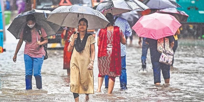 People wade through a flooded road in Mumbai on Tuesday