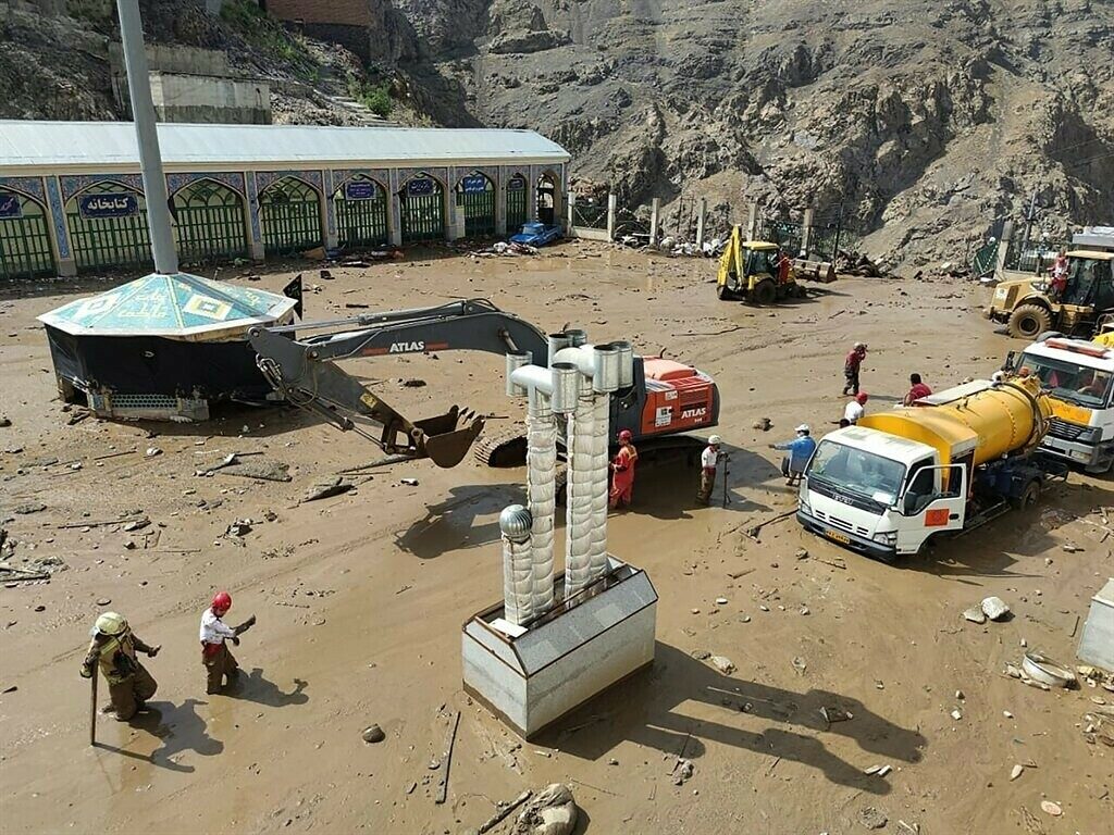 A handout picture provided by the Iranian Red Crescent shows members of a rescue team working at the site of a flash flood in the Emamzadeh Davoud northwestern part of Tehran, on July 28 2022.