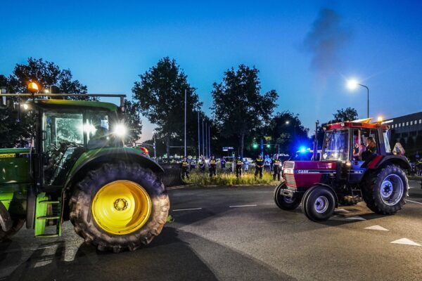 Tractors drive by Dutch police officers