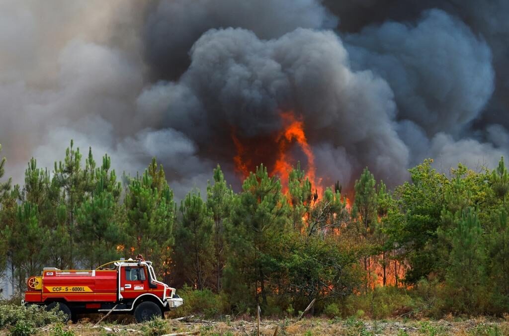 A firefighting truck works to contain a fire in Saint-Magne, as wildfires continue to spread in the Gironde region of southwestern France, August 11, 2022.