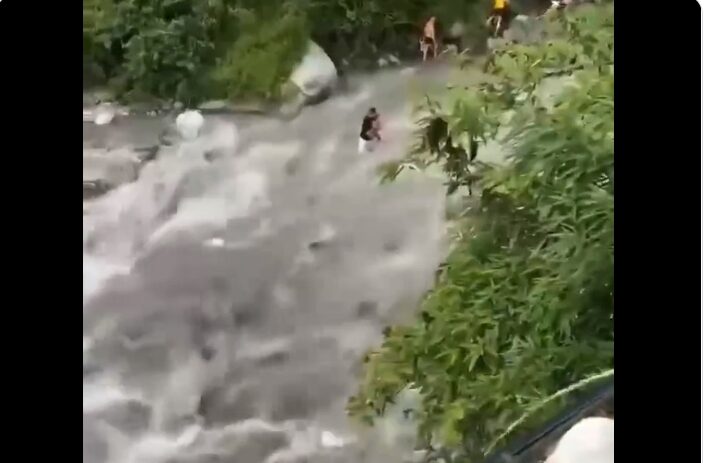 A father holding his son standing in the flood in Longcaogou, Southwest China's Sichuan Province on August 14.