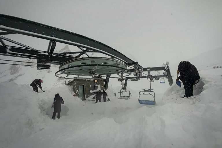 workers clearing the media platforms of snow so that they work correctly.