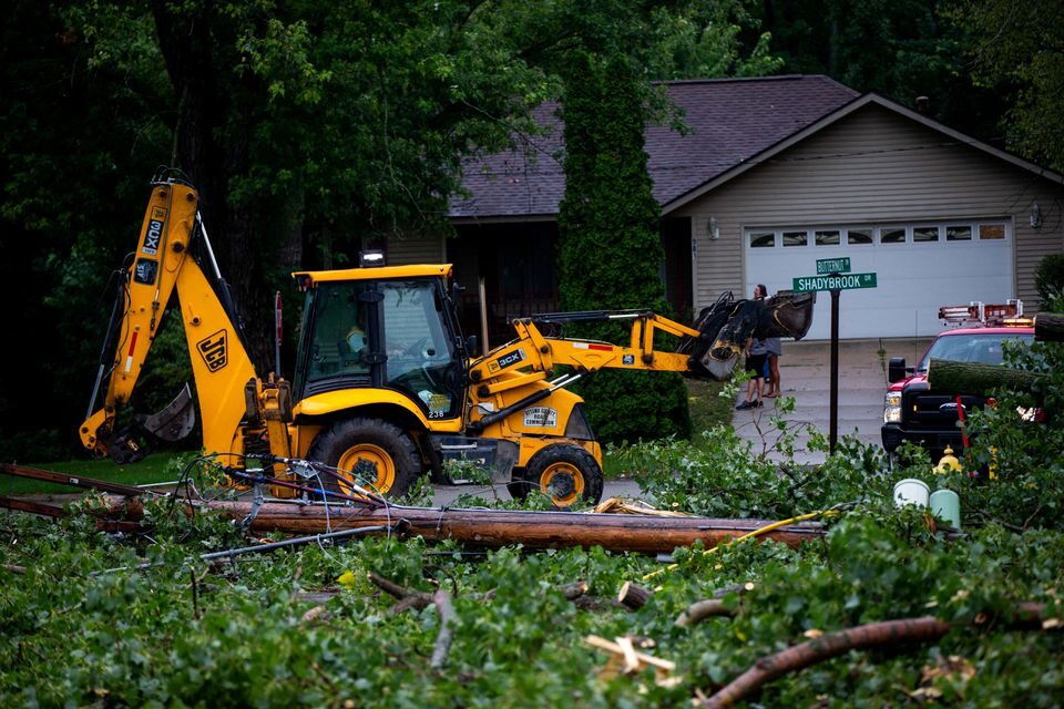 Fallen tree limbs are cleared after thunderstorms and high winds downed power lines and closed roads in Holland, Michigan, U.S. August 29, 2022.