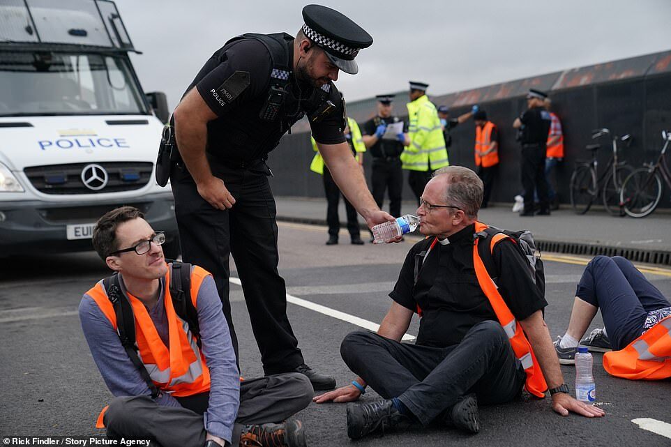 extinction rebellion block britain road cop water