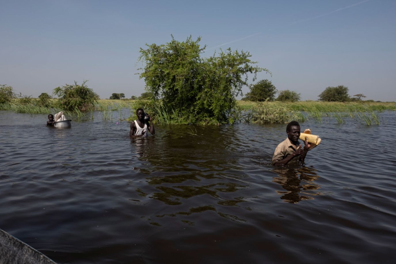 A family moves through floodwaters