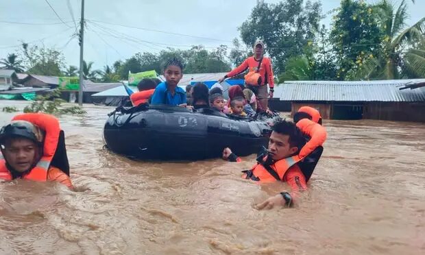 Click to enlarge Philippine rescuers evacuate people from floods from Severe Tropical Storm Nalgae in Parang, Maguindanao province.
