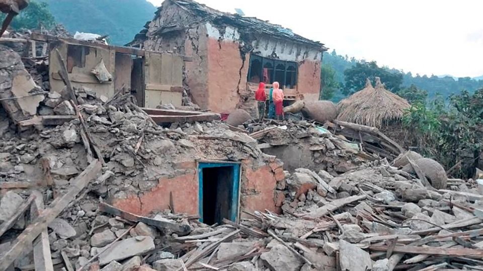 Click to enlarge People outside the ruins of collapsed houses in the district of Doti after an earthquake struck Nepal on November 9, 2022.