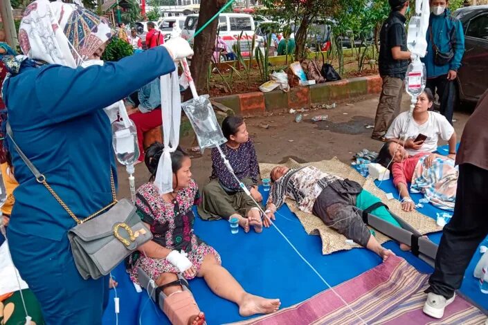 Click to enlarge People injured during an earthquake receive medical treatment in a hospital parking lot in Cianjur, West Java, Indonesia (