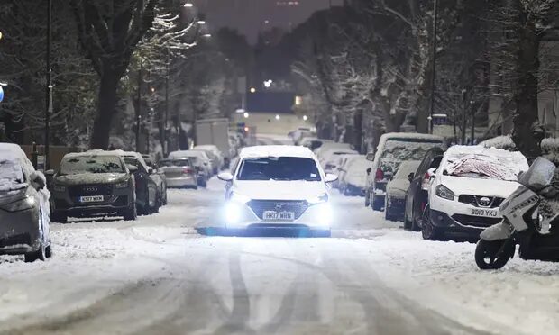 Click to enlarge A car drives along a snow-covered road in the early morning at Willesden Green, north-west London.
