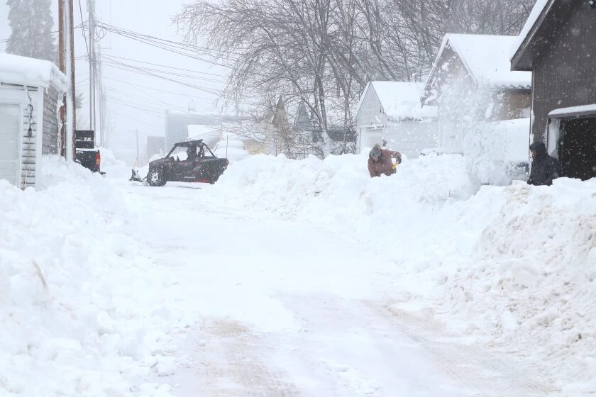 Click to enlarge A shovel, a snowblower and an ATV plow are all being used to clear snow in a Proctor alley off First Avenue Thursday morning.