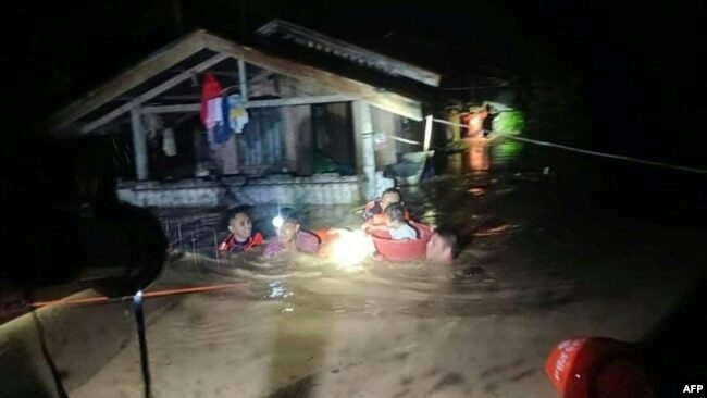 This handout photo taken on Dec. 25, 2022 and received on Dec. 26 from the Philippine Coast Guard shows rescuers evacuating people from a flooded area in Ozamiz City, Misamis Occidental.