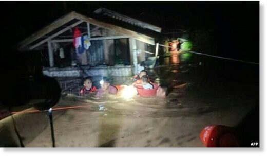 Click to enlarge This handout photo taken on Dec. 25, 2022 and received on Dec. 26 from the Philippine Coast Guard shows rescuers evacuating people from a flooded area in Ozamiz City, Misamis Occidental.