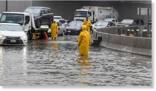 Click to enlarge People walk through floodwater following heavy rain in Jeddah, Saudi Arabia on 24 November 2022