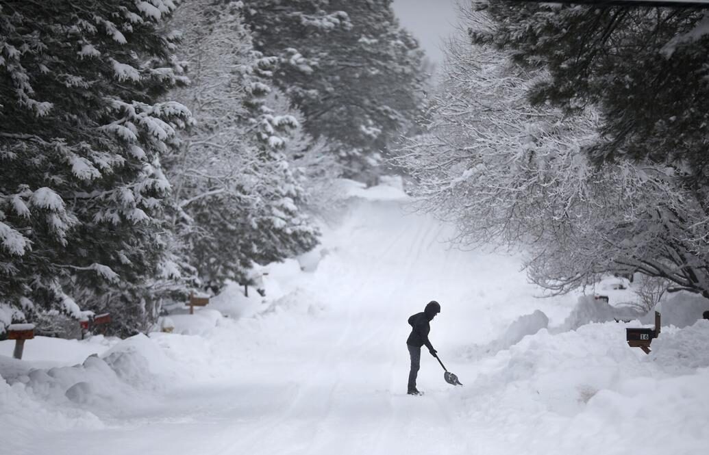 In the middle of a series of winter storms that brought more than 20 inches of snow to Flagstaff in 48 hours, a woman digs out her driveway Monday morning as snow continues to fall.