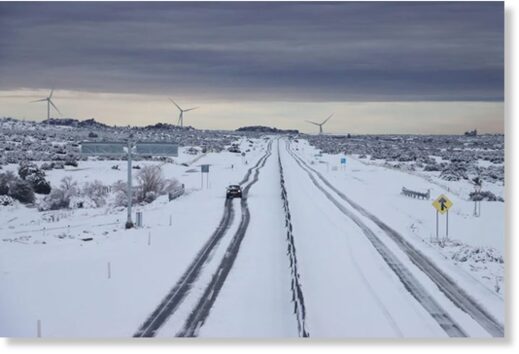 A lone car navigates a snowy highway near La Rumorosa, Baja California.