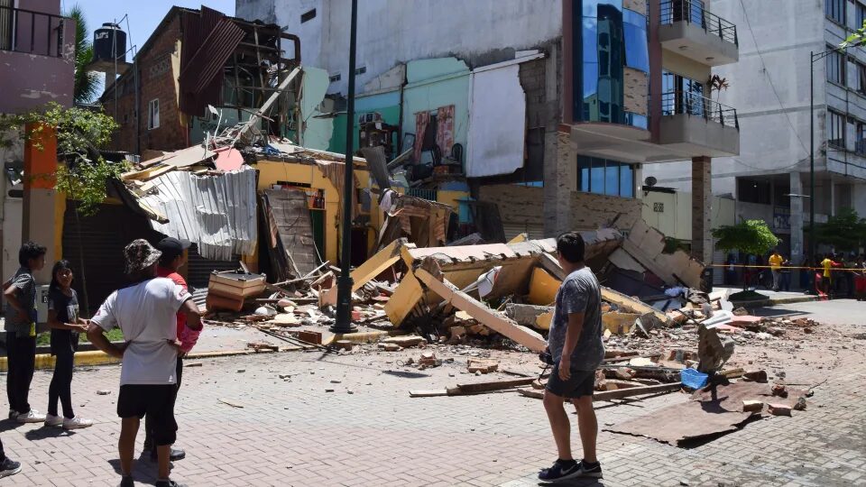 Click to enlarge Residents look at a building that collapsed after an earthquake struck Machala, Ecuador, on March 18, 2023.