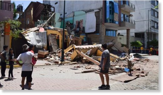 Residents look at a building that collapsed after an earthquake struck Machala, Ecuador, on March 18, 2023.