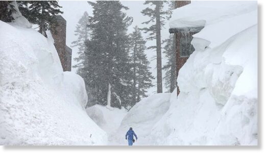 Click to enlarge A person walks near snowbanks obscuring condominiums as snow falls in the Sierra Nevada mountains from yet another storm system which is predicted to bring heavy snow to higher elevations on March 28, 2023, in Mammoth Lakes, Calif