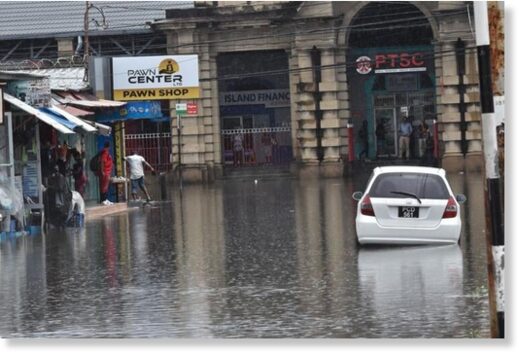 Click to enlarge Widespread: Lower Henry Street leading onto South Quay, left, was covered in water, making it impassable to both vehicular and pedestrian traffic following yesterday’s heavy rains in downtown Port of Spain.