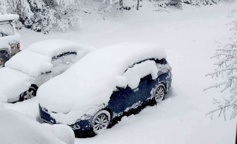 Vehicles buried in more than foot of snow in Ishpeming, Michigan on May 1, 2023.
