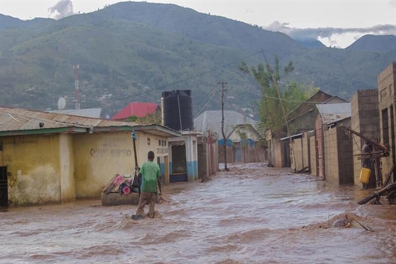 A man tries to cross a flooded street in Uvira,