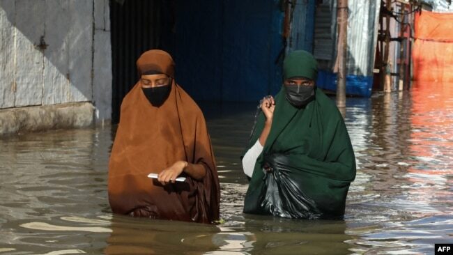 Click to enlarge Women walk through floodwater in Beledweyne, Somalia, May 12, 2023.