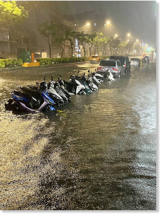 Click to enlarge Motorcycles partly submerged in floodwaters are pictured on Nanshan Road in Taoyuan’s Lujhu District on Monday.