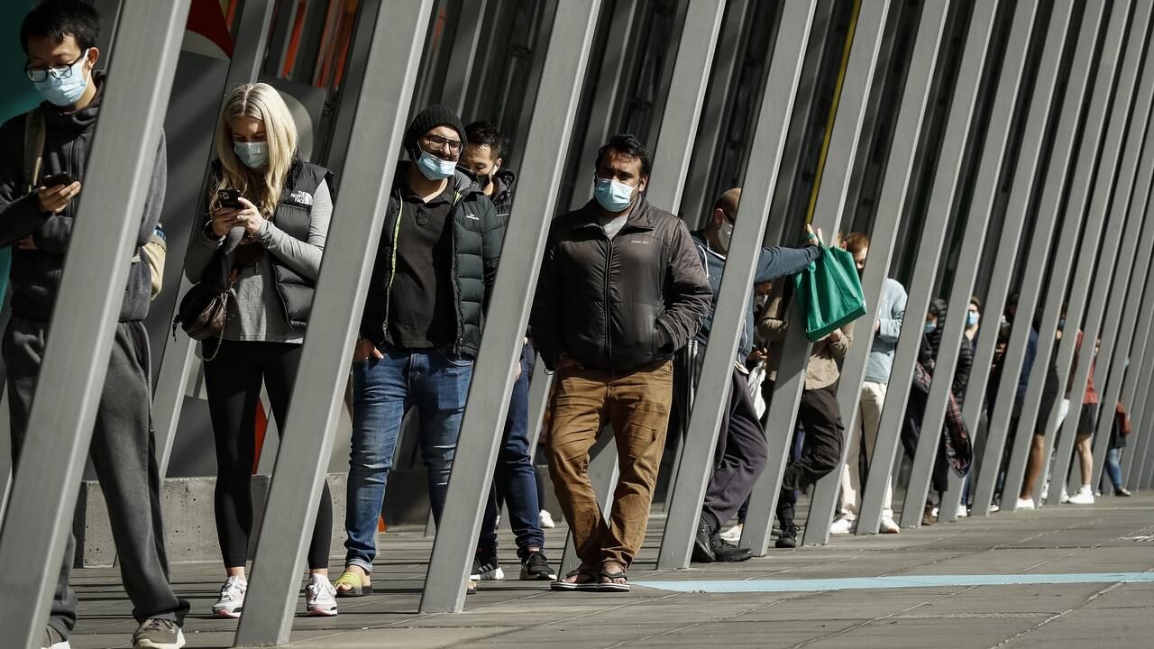 Click to enlarge People line up at a vaccine hub in Melbourne.