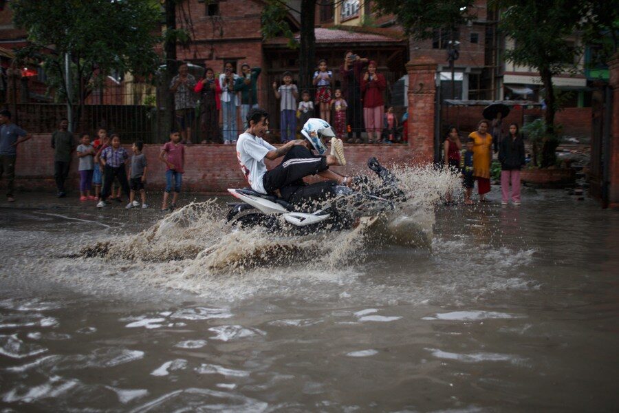Click to enlarge People ride motorcycle on a flooded street in Kathmandu, Nepal, July 23, 2023.
