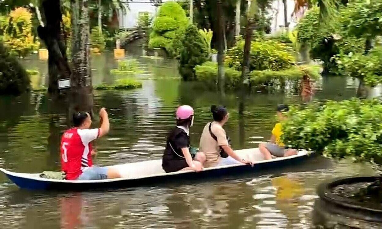 Click to enlarge A man rows a boat carrying three other people in