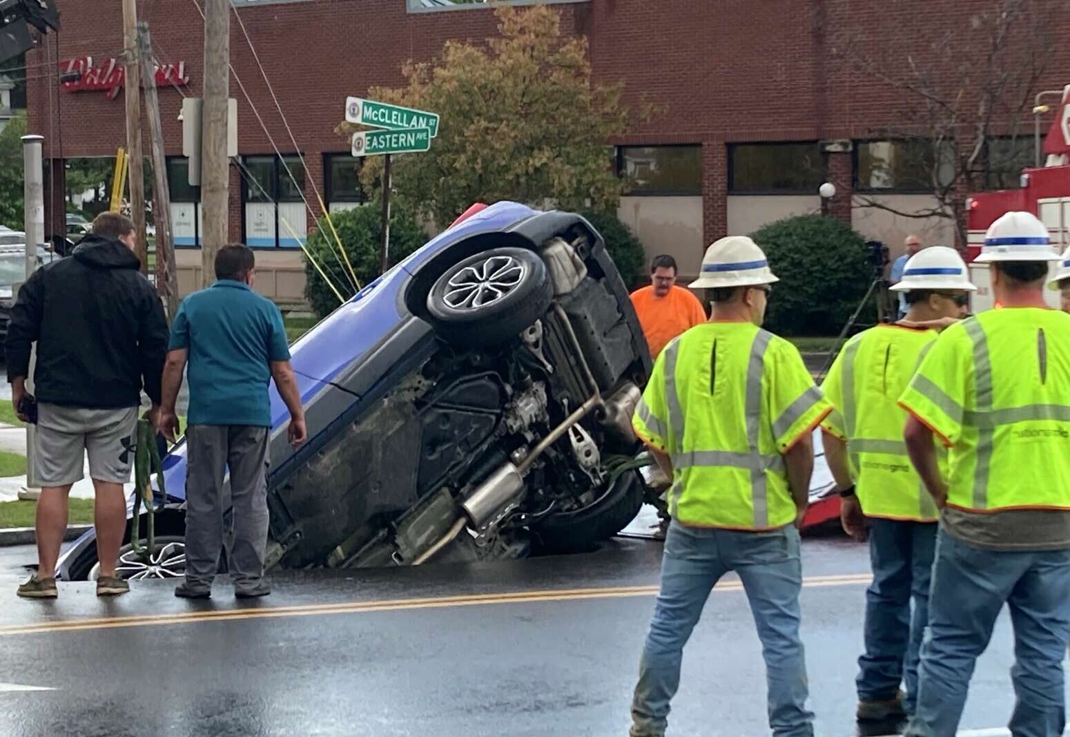 Emergency crews were trying to figure out how to right a car that was swallowed by a sinkhole at McClellan Street and Eastern Avenue Monday evening, July 31, 2023.