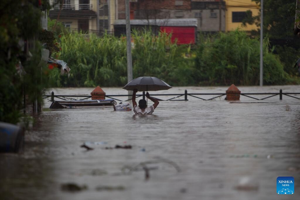 A man wades through flood water in Kathmandu, Nepal on Aug. 8, 2023.
