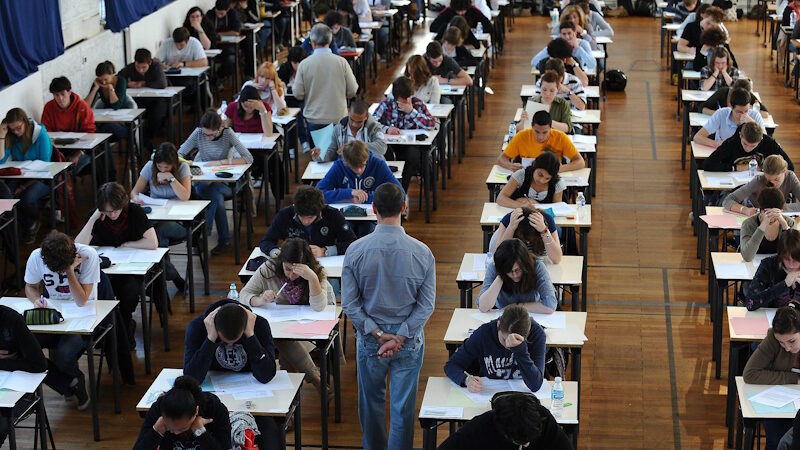 students sit exam paper pencil chatgpt cheating