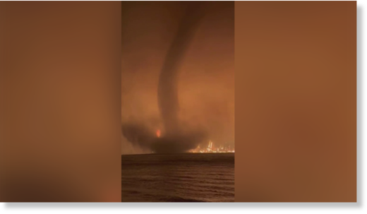 A waterspout is seen spinning in front of a massive wildfire in Canada.