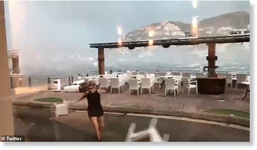 A woman sprints for cover as chairs behind her get picked up by the winds in Majorca on Sunday