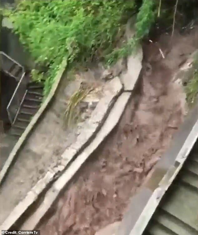 A river of muddy water running towards a road in Blevio. Heavy rain and landslides have caused damage in the area