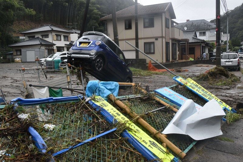 A car is seen resting next to a toppled fence in the wake of Typhoon Yun-yeung following flooding of a river in the Fukushima Prefecture city of Iwaki on Sept. 9, 2023.