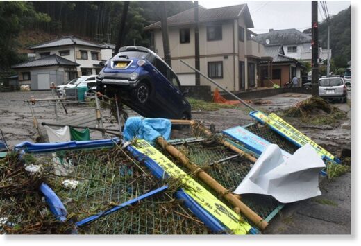 Click to enlarge A car is seen resting next to a toppled fence in the wake of Typhoon Yun-yeung following flooding of a river in the Fukushima Prefecture city of Iwaki on Sept. 9, 2023.