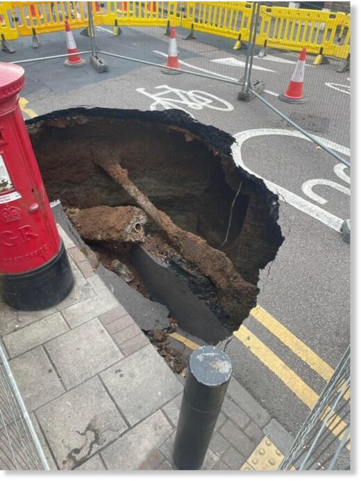 Click to enlarge Residents initially used wheelie bins to block off the sinkhole, which emerged on Monday morning in Eltham.
