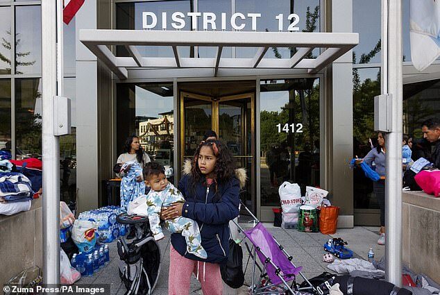 Click to enlarge A family from Venezuela outside the Chicago Police 12th District station