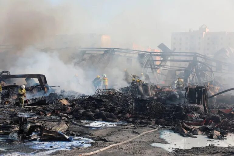 Click to enlarge Specialists work to extinguish fire following an explosion at a warehouse near an airport in Tashkent