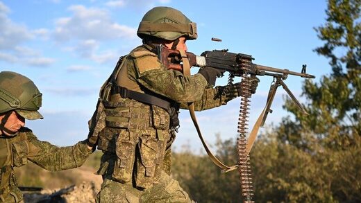 A Russian military recruit shoots a machine gun during combat tactic and shooting practice exercises.