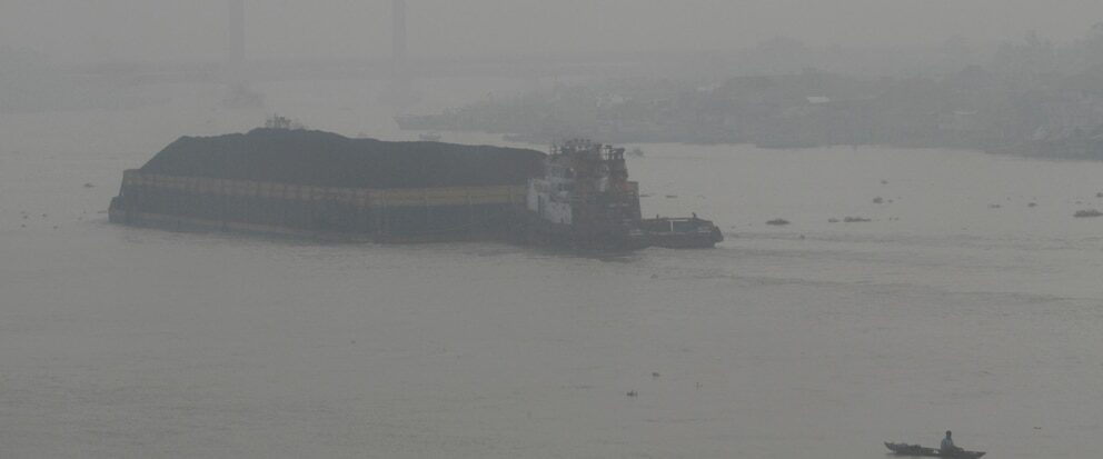 A boat sails on Musi River as thick haze from forest fires