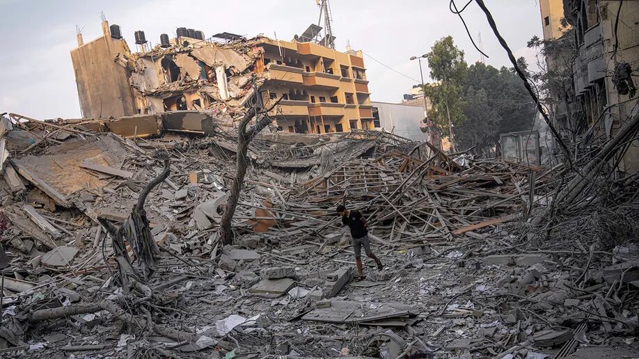 Palestinians inspect the rubble of a building after it was struck by an Israeli airstrike, in Gaza City
