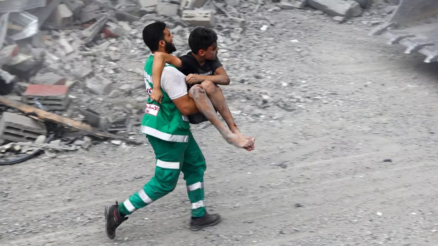 Click to enlarge Palestinian civil defence carries a wounded boy