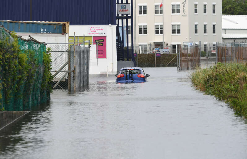 Click to enlarge Drivers did their best to navigate flooding after heavy rainfall across the island. Pictured is a car stuck on Mill Creek Road