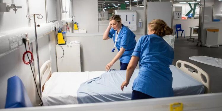 Click to enlarge nurses prepare bed