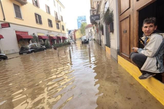 A man looks at a flooded street in Milan, Italy on Tuesday after a storm caused the Seveso river to burst its banks. Lake Como also overflowed in the storm that brought heavy rainfall and strong winds.